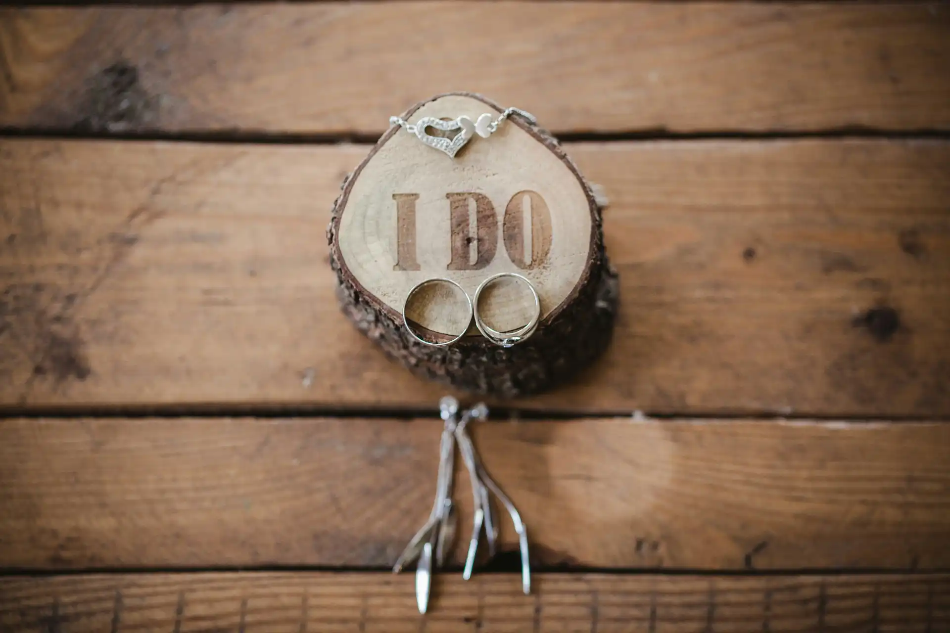 Deux alliances sur un morceau de bois gravé I DO